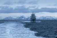 Fregatt seler på bølgete hav i vinteromgivelser
