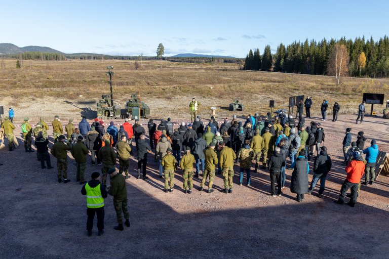 A group of people in a military firing range. Norwegian autumn landscape.